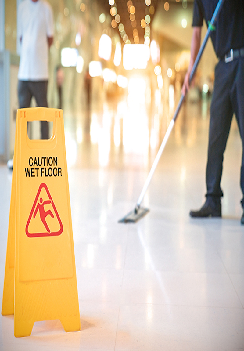 Day porter cleaning service cleaning up a spill in a commercial building